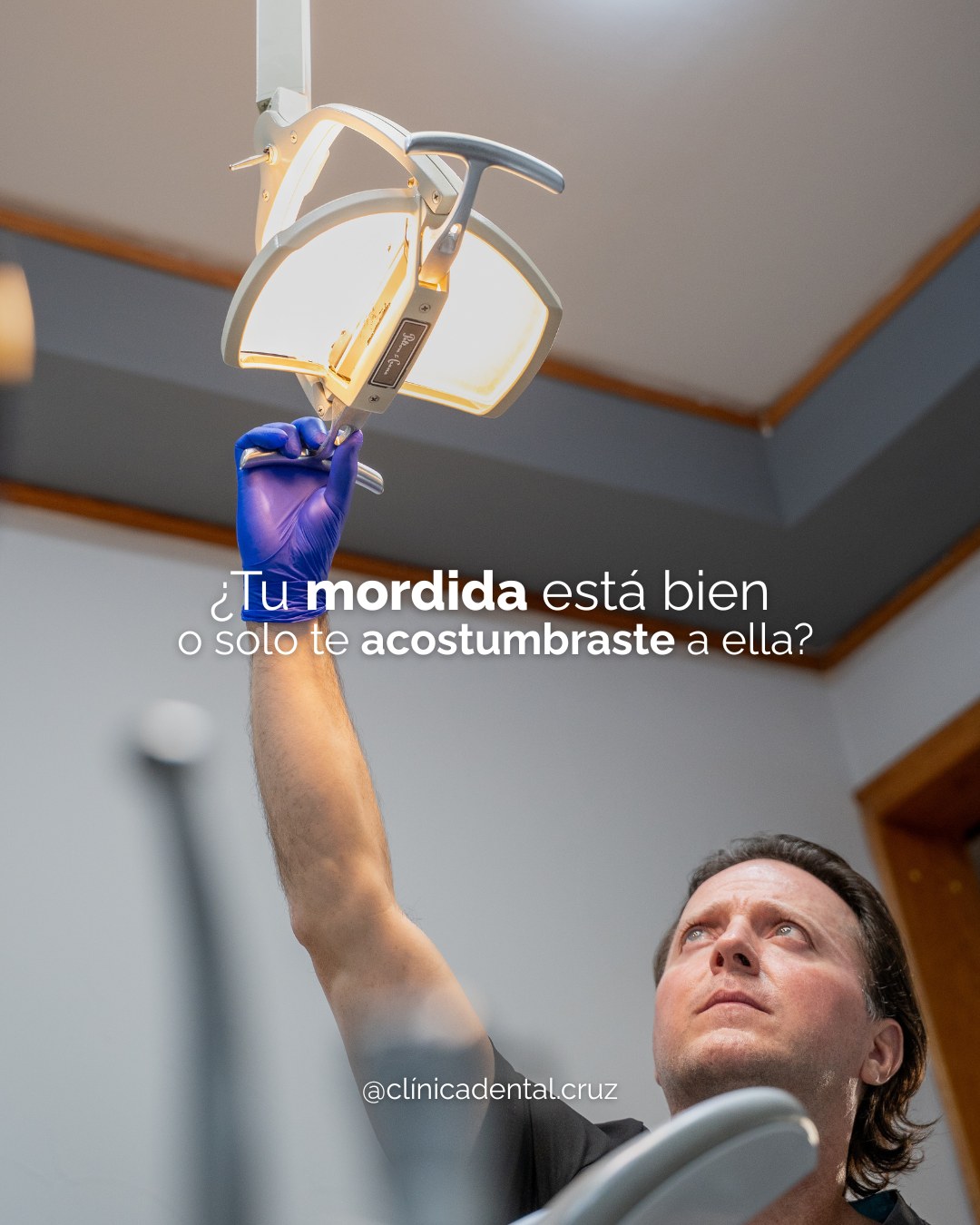 Pieza de Clínica Dental Cruz con el doctor ajustando la lámpara del consultorio