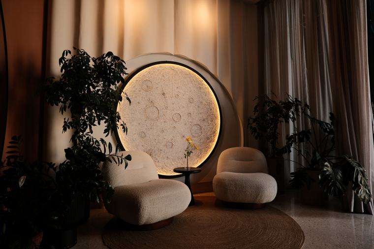 Sala de estar de MUNA con una luna iluminada empotrada en el muro