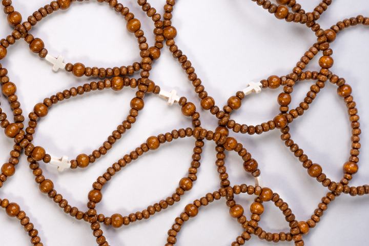 Pulseras de rosario de madera extendidas sobre fondo claro